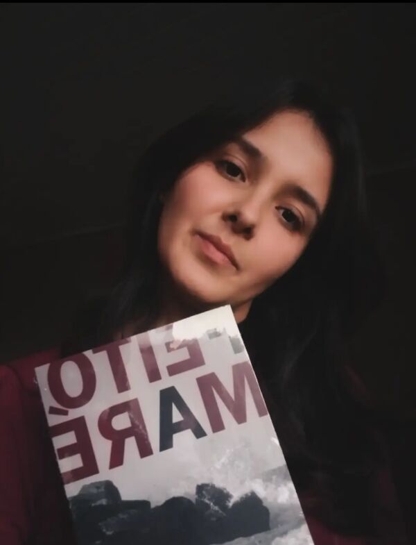 Autora segurando seu livro publicado